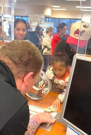 Malia Dudley, 4, of Antelope reaches for her $1 withdrawl