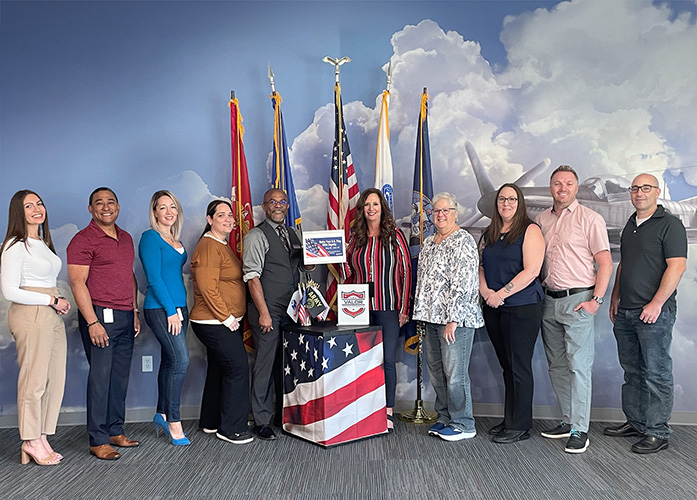Members of SAFE's VALOR pose with U.S. flag collection bin in McClellan Room at the credit union's HQ 2_500px