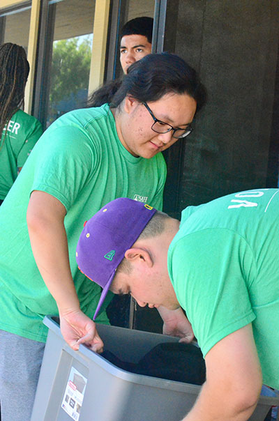 SAFE Interns Andrew Ramos sort donated clothing for professional working moms.