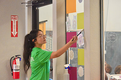 SAFE Credit Union intern Nohemy Garcia paints a classroom.