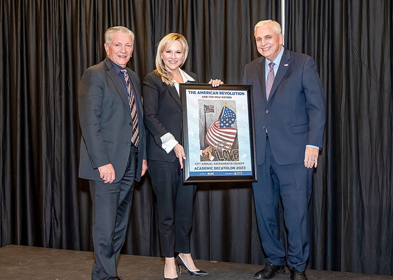 SAFE Credit Union Board Chair Terry Tremelling, SAFE Credit Union President/CEO Faye Nabhani, and Sacramento County Office of Education Superintendent David Gordon showcase the Sacramento Academic Decathlon winning poster artwork.