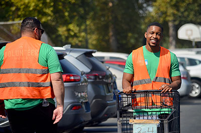 Personal Relationship Officer at SAFE's Land Park Branch, Akeal Ellis of Rancho Cordova, helps move carts for Rancho Cordova Food Locker guests.