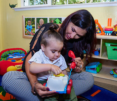 Yolo Crisis Nursery staff member illustrates the nursery's services with a community model.