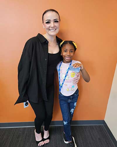 SAFE Credit Union Relationship Officer Kailey Hart, left, poses with London Grant